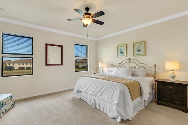 carpeted bedroom featuring ceiling fan and ornamental molding