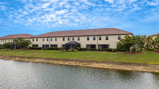 back of house featuring a yard and a water view