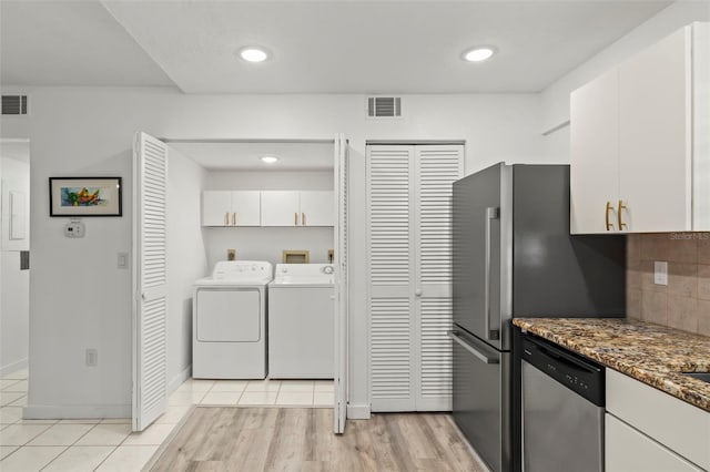 kitchen with white cabinets, dishwasher, dark stone counters, tasteful backsplash, and independent washer and dryer