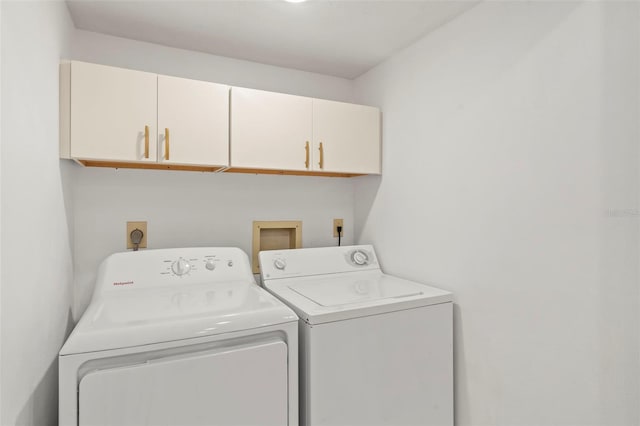 washroom featuring cabinets and washing machine and clothes dryer