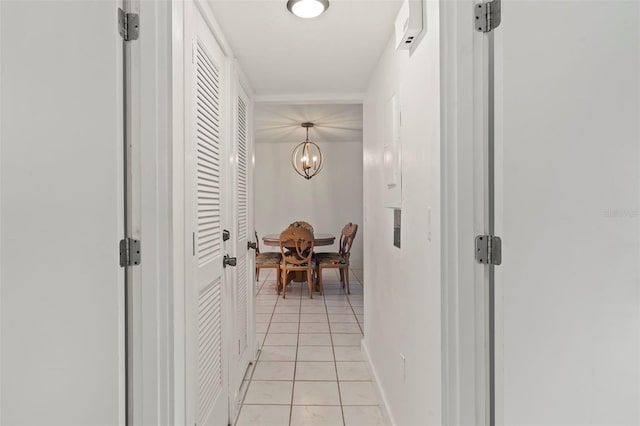 corridor featuring a notable chandelier and light tile patterned flooring