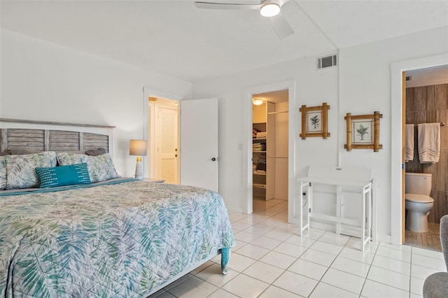 tiled bedroom with ensuite bathroom and ceiling fan