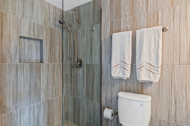 bathroom with toilet and a tile shower