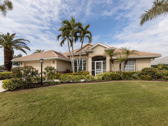 ranch-style house featuring a garage and a front lawn