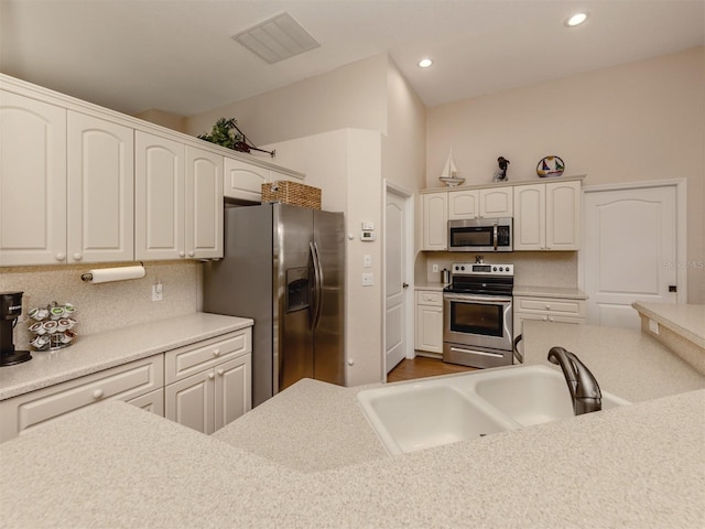 kitchen featuring sink, white cabinets, appliances with stainless steel finishes, and tasteful backsplash