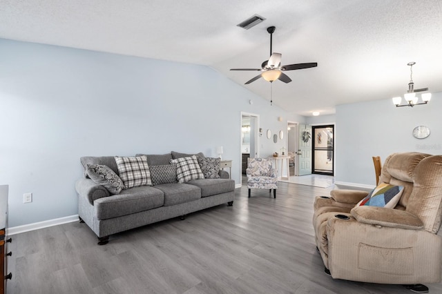 living room with ceiling fan with notable chandelier, vaulted ceiling, and light hardwood / wood-style floors