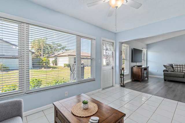 interior space featuring light tile patterned flooring, ceiling fan, and a textured ceiling