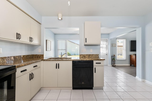 kitchen featuring sink, white cabinetry, plenty of natural light, dark stone counters, and black appliances