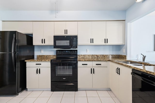 kitchen featuring white cabinetry, dark stone countertops, sink, and black appliances