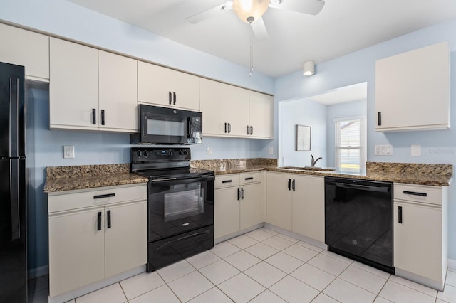 kitchen featuring white cabinetry, sink, dark stone countertops, and black appliances