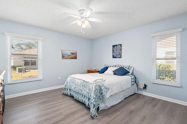 bedroom with ceiling fan, hardwood / wood-style floors, and a textured ceiling