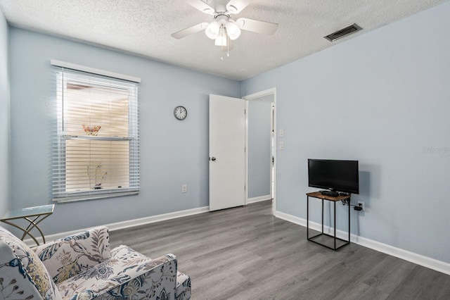 sitting room featuring hardwood / wood-style floors, a textured ceiling, and ceiling fan