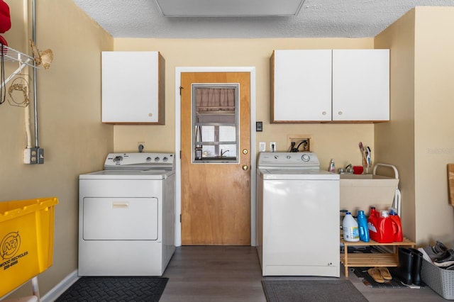 laundry area with cabinets, washer and dryer, dark wood-type flooring, and a textured ceiling