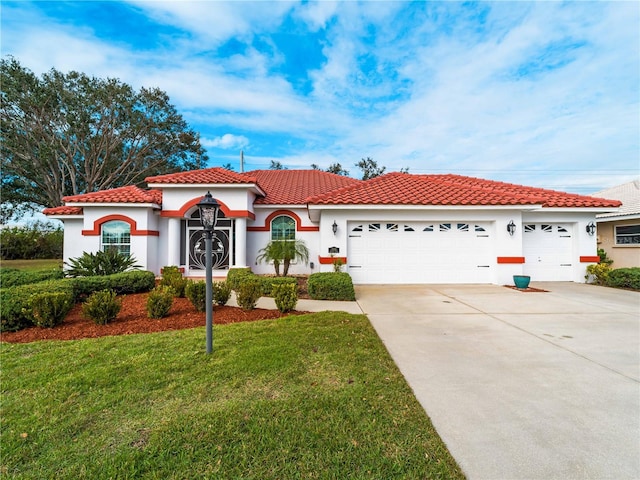 mediterranean / spanish home featuring a garage and a front lawn