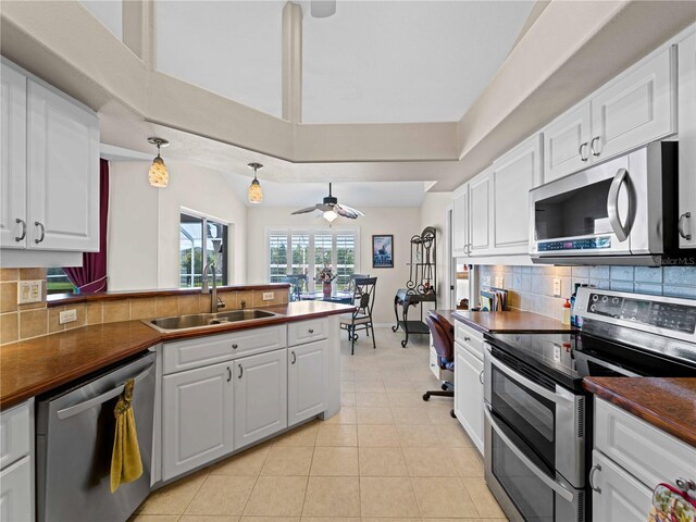 kitchen featuring white cabinetry, ceiling fan, stainless steel appliances, tasteful backsplash, and sink