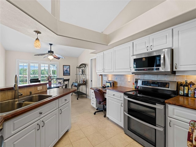 kitchen with ceiling fan, vaulted ceiling, sink, stainless steel appliances, and white cabinets