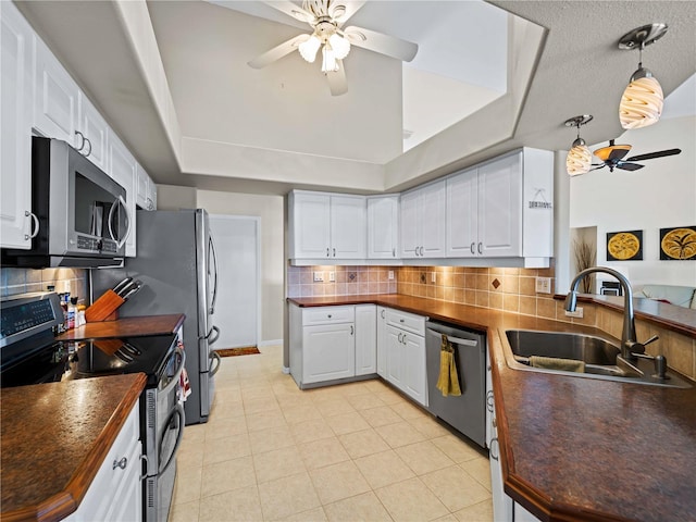 kitchen with tasteful backsplash, sink, white cabinetry, stainless steel appliances, and light tile patterned floors