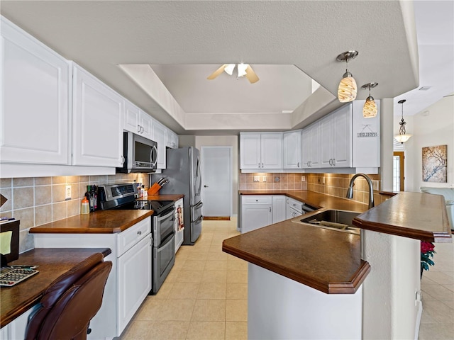 kitchen with sink, hanging light fixtures, appliances with stainless steel finishes, and white cabinets