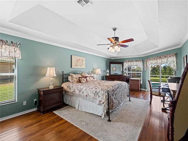 bedroom featuring a raised ceiling, ceiling fan, dark hardwood / wood-style flooring, and crown molding