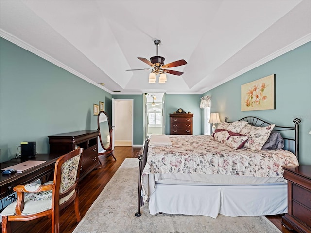 bedroom with dark hardwood / wood-style floors, ceiling fan, crown molding, and a raised ceiling