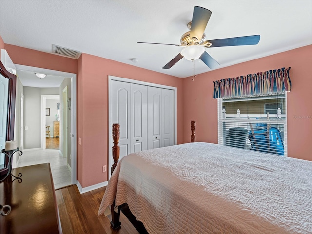 bedroom with ceiling fan, a closet, and wood-type flooring