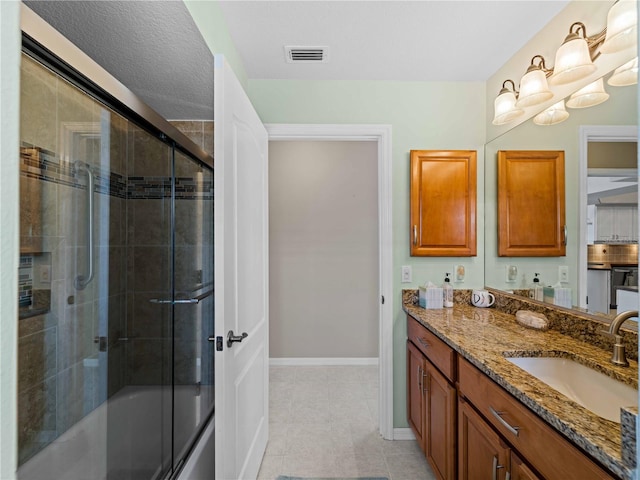 bathroom with tile patterned floors, shower / bath combination with glass door, and vanity