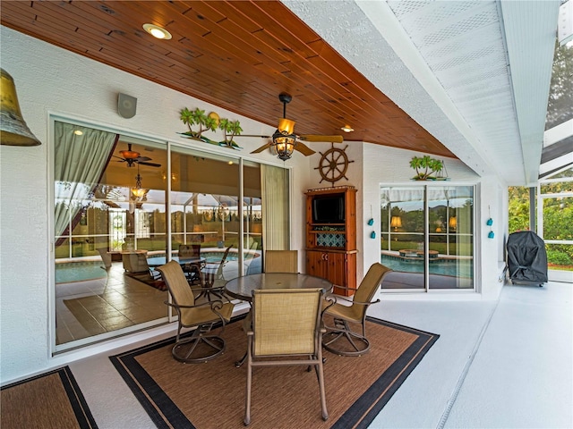 sunroom featuring ceiling fan and wood ceiling