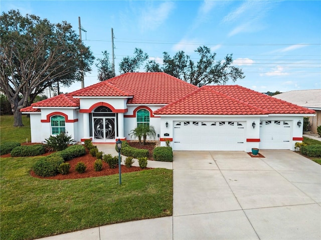 mediterranean / spanish home with a front lawn and a garage