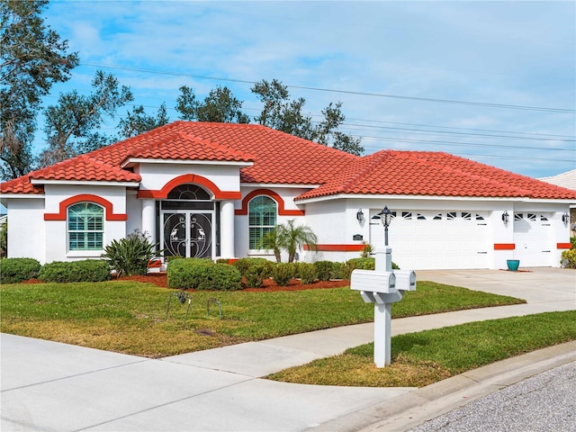 mediterranean / spanish home featuring a front lawn and a garage