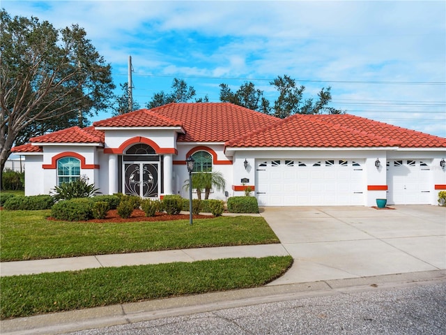 mediterranean / spanish home with a front lawn and a garage