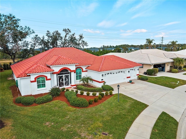 mediterranean / spanish home featuring a front lawn and a garage