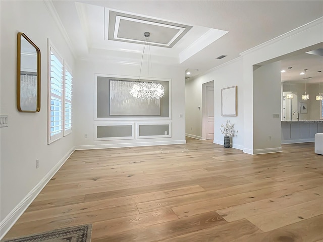 interior space featuring crown molding, light hardwood / wood-style floors, and a raised ceiling