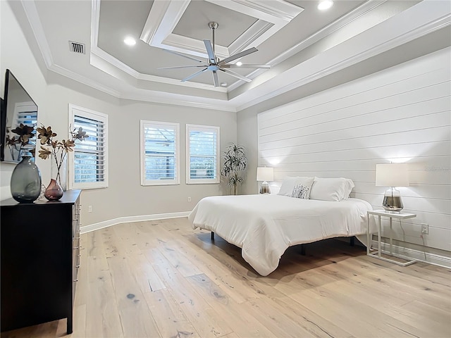 bedroom with multiple windows, crown molding, coffered ceiling, and light hardwood / wood-style floors