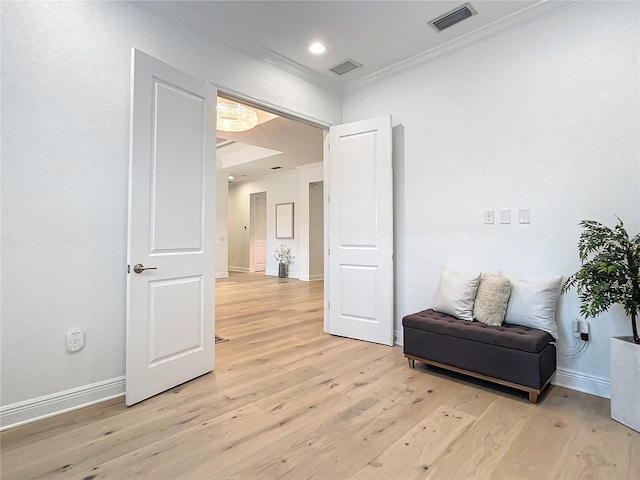 living area with crown molding and light hardwood / wood-style floors