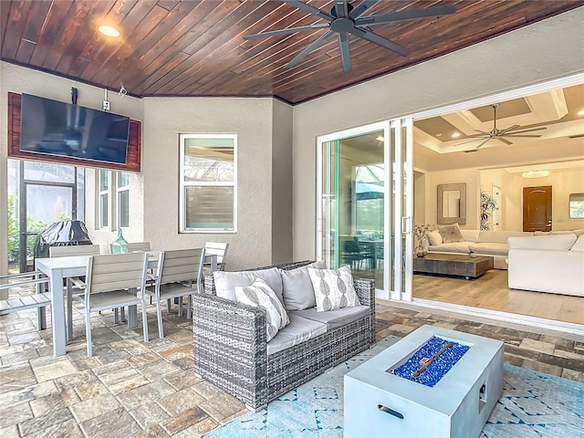 view of patio / terrace featuring ceiling fan and an outdoor living space with a fire pit