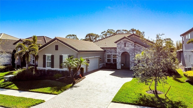 mediterranean / spanish-style home featuring a garage and a front lawn