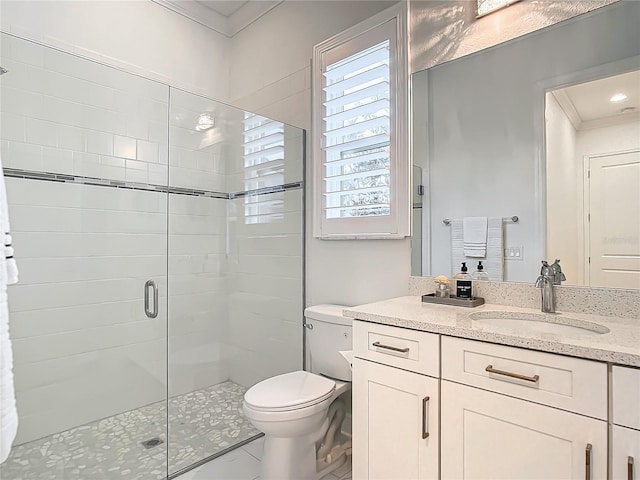 bathroom featuring vanity, a shower with shower door, ornamental molding, and toilet