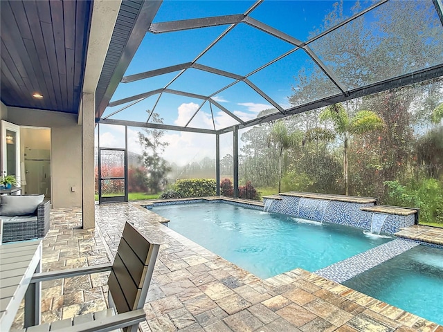 view of pool with a patio area, an in ground hot tub, pool water feature, and glass enclosure