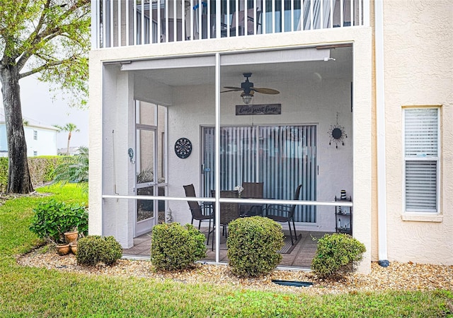 property entrance with a balcony and ceiling fan