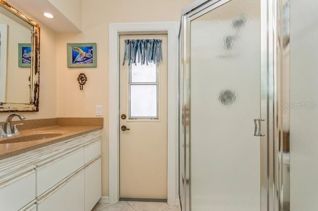 bathroom with vanity and a shower with door