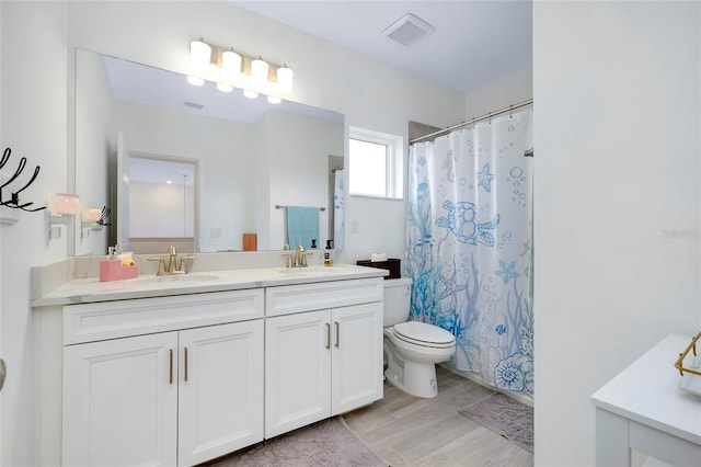 bathroom with hardwood / wood-style flooring, vanity, toilet, and curtained shower