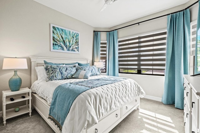 bedroom featuring light carpet and baseboards