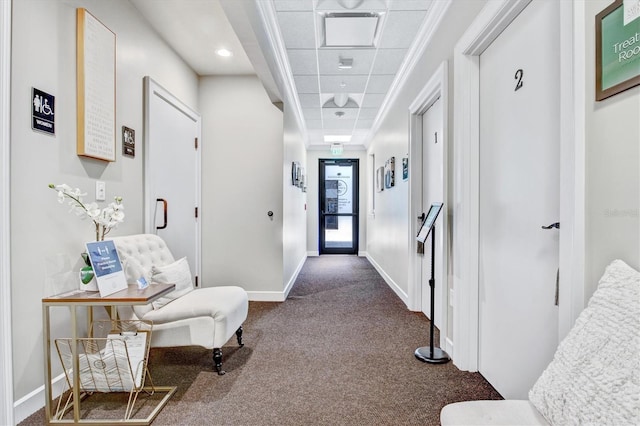 corridor featuring a paneled ceiling and carpet