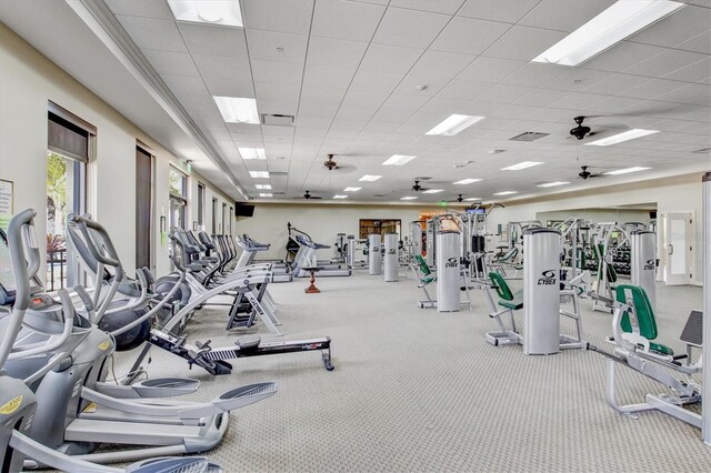 gym with visible vents, a drop ceiling, and a ceiling fan