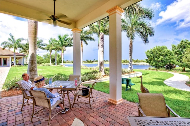 view of patio featuring a water view and ceiling fan