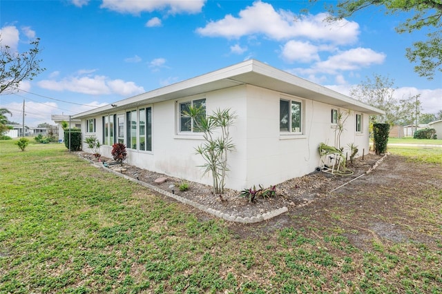 view of side of home with a yard