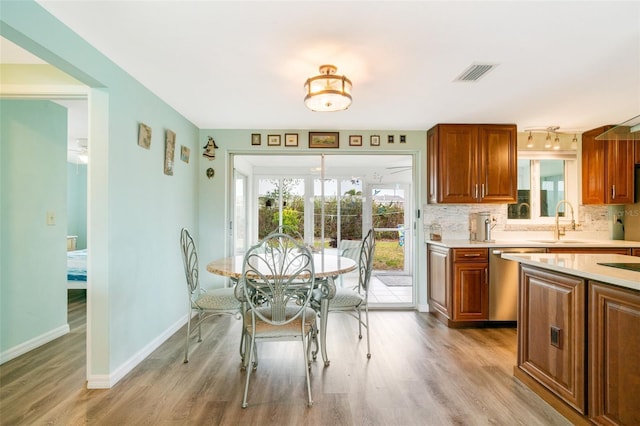 dining space with sink and light wood-type flooring