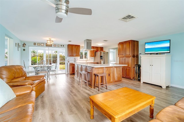 living room with ceiling fan and light hardwood / wood-style flooring