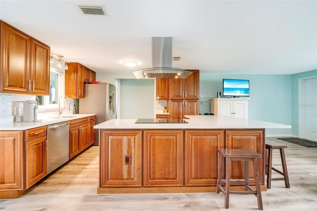 kitchen featuring dishwasher, sink, light wood-type flooring, a kitchen island, and island range hood