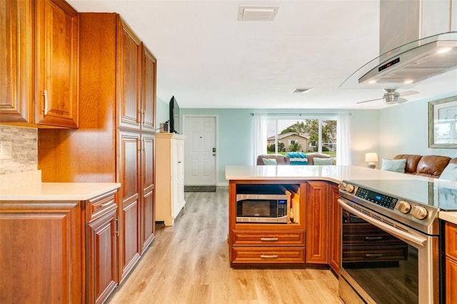 kitchen with kitchen peninsula, light hardwood / wood-style flooring, appliances with stainless steel finishes, and tasteful backsplash